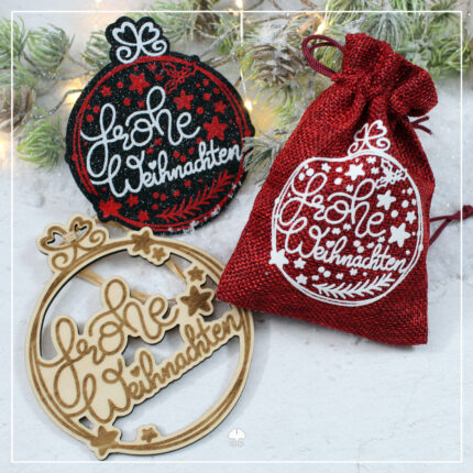 Zu sehen ist das Lettering "Frohe Weihnachten" in einer Weihnachtskugel. Einmal als Plott auf Filz, dann als Plott auf einem kleinen Jutesack und als Umsetzung mit dem Laser. Da wurde der Schriftzug und die Grafik graviert, die Konturen wurden mit Offsett ausgeschnitten.