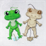 Zwei Varianten der Datei Hampelbauernhof "Frosch" aus Holz. Eine wurde mit dem Laser graviert und geschnitten. Die andere wurde mit der Laubsäge ausgesägt und dann mit Acrylfarben bemalt.