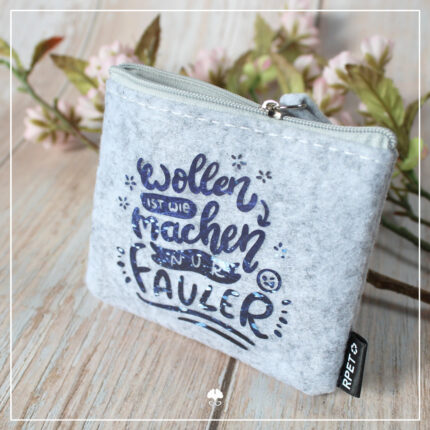 Beispiel für die Datei Lettering "Wollen ist wie machen". Zu sehen ist ein kleines Etui aus Filz mit Reißverschluß. Der Spruch wurde aus dunkelblauer Flexfolie darauf geplottet.