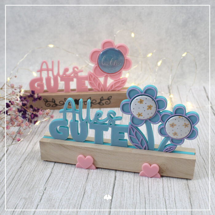 Abgebildet sind die 25er und 38er Buttonvariante der 3D Klötzchenschrift "Alles Gute" - 3D Druckdatei. Sie wurden beide mit hellen Klötzchen kombiniert. Beim Filament wurden rosa und blau mit lila genutzt.