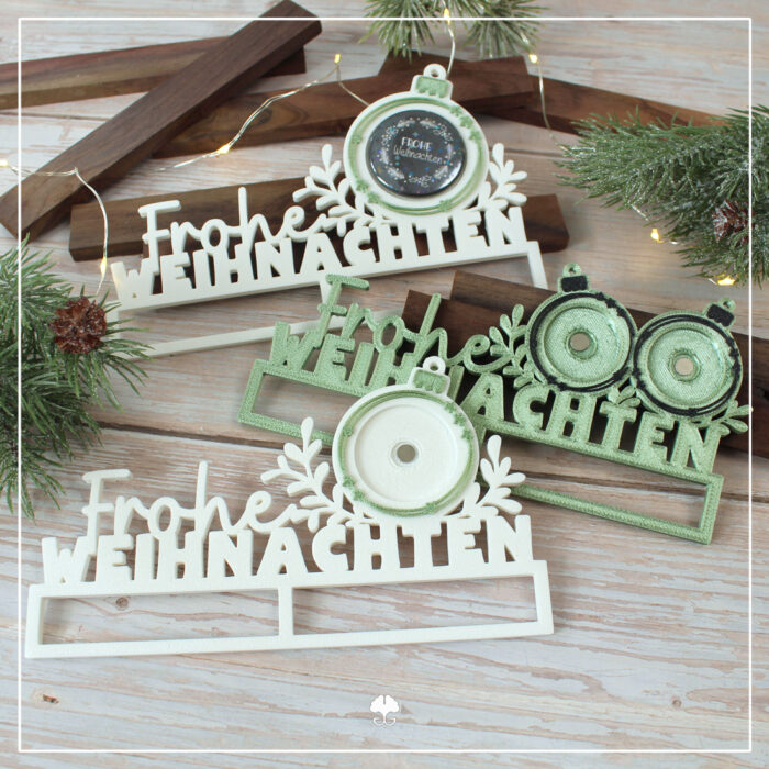 Abgebildet sind alle drei Varianten der 3D Klötzchenschrift "Frohe Weihnachten" - 3D Druckdatei, welche mit Buttons kombiniert werden können. Die Versionen für den 32er und 38er Button wurde einfarbig aus weißem Filament gedruckt. Für die 25er Version wurde Silk-Filament in grün genutzt.