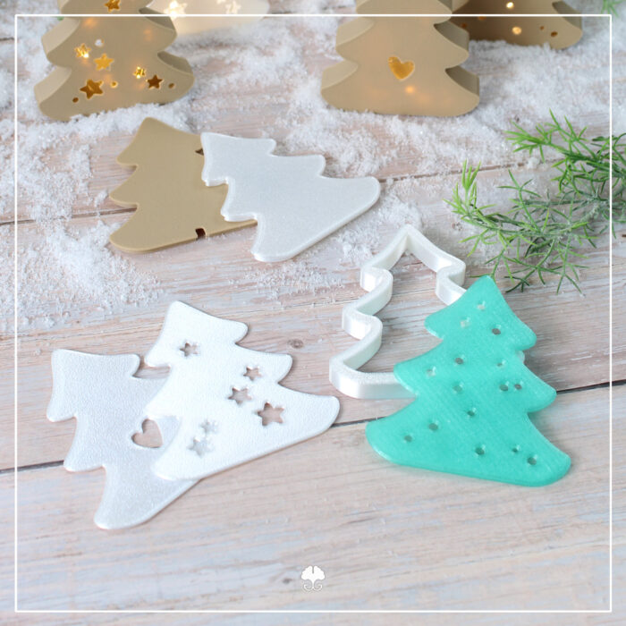 Abgebildet sind einige flache Varianten sowie der Rahmen der 3D "Lichtertannen" - Druckdatei. Die Bestandteile sind aus weißem Silk- , türkisem transluzenten und holzfarbenem Filament gedruckt.