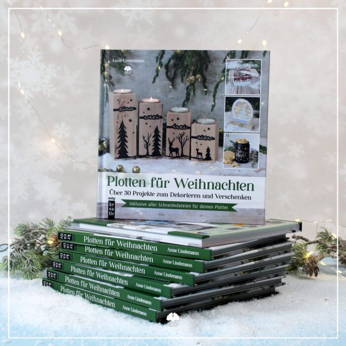Es ist ein Stapel Bücher "Plotten für Weihnachten" abgebildet. Mehrere liegen übereinander und eins wurde direkt darauf aufgestellt. Das Cover zeigt nach vorne.