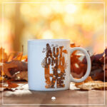 Eine weiße Tasse auf welcher das Lettering "Autumnlove" aufgebracht wurde. Das Design hat einen Farbverlauf von verschiedenen Orange- und Brauntönen.