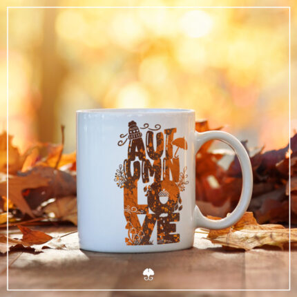 Eine weiße Tasse auf welcher das Lettering "Autumnlove" aufgebracht wurde. Das Design hat einen Farbverlauf von verschiedenen Orange- und Brauntönen.