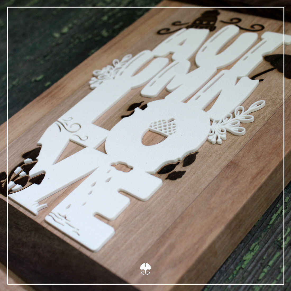 Lettering "Autumn Love" - Beispiel als 3D Druck auf einem Holzzschild Detailaufnahme: Ein Schild aus verschiedenen Klötzchen. Die dekorativen Elemente der Lettering "Autumnlove" - Plotterdatei wurden mit dem Laser graviert. Der Schriftzug selbst ist ein 3D-Druck in weiß.