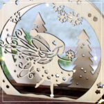 Die Mini-Lichterbogen "Winterfee" wurde aus Sperrholz mit dem Laser geschnitten. Das Motiv wurde mit dunklen Klötzchen kombiniert.