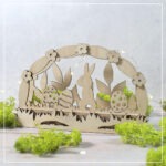 Ein Mini-Lichterbogen aus drei Ebenen mit Klötzchen kombiniert. Das Motiv zeigt einen Hasen der im Gras umgeben von Ostereiern sitzt. Die Motive wurden aus Holz mit dem Laser geschnitten.