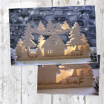 Vorschau des Lichterbogen "Winterspirit". Zu sehen ist der fertig gebaute Schwibbogen. Er ist aus Sperrholz gefertigt, dreiteilig und zeigt eine verschneite Winterlandschaft. Sie besteht aus einem Haus, Tannen und Rehen.